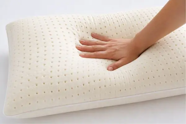 Brooklyn Bedding Talalay Latex Pillow Review (2026 Guide + Real Testing) 3 Hand pressing Brooklyn Bedding Talalay latex pillow to show bounce